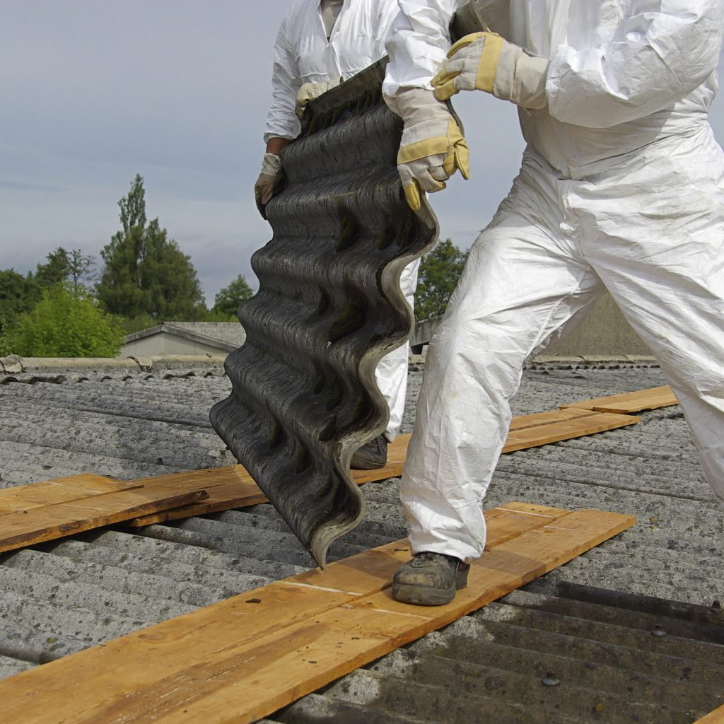 Two workers handling asbestos in protective gear